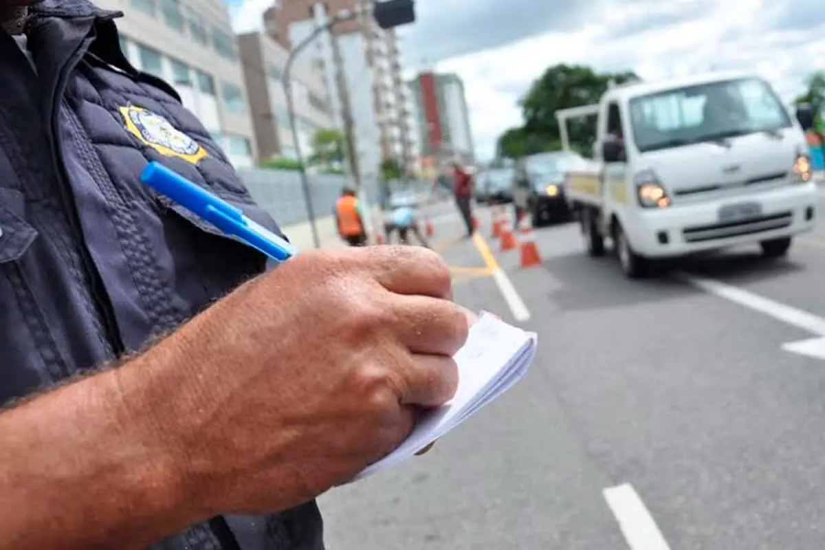 Agente de trânsito registrando autuação de infração na via pública
